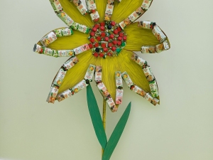 A flor em exposição, após término da mesma. No centro da flor, estão as tampas das embalagens.