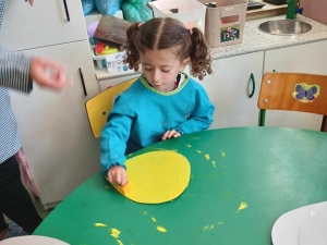 Pintura das pétalas da flor através de tinta guache amarela e pincel