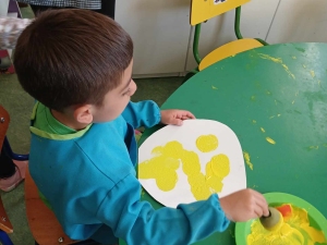 Pintura das pétalas da flor através de tinta guache amarela e pincel