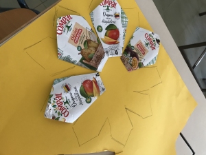Construção das pétalas da flor com embalagens da Compal.