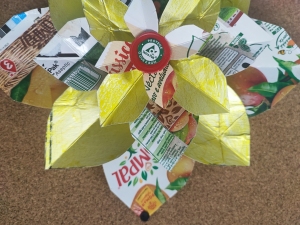 Centro da flor com símbolo da Tetra Pak e visível uma embalagem Compal.